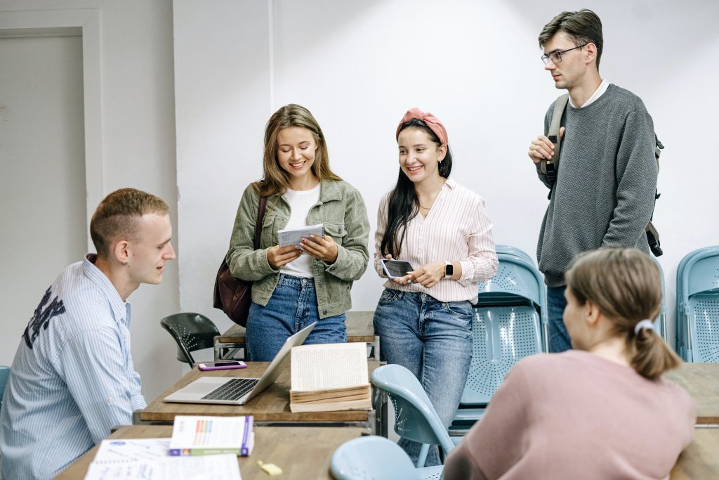 Viisi henkilöä työskentelevät ja keskustelevat yhdessä.
