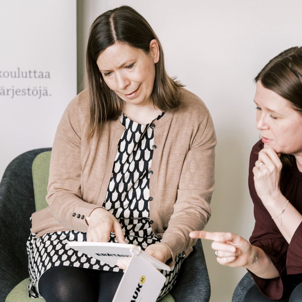 Kaksi ihmistä istuu ja keskustelee.